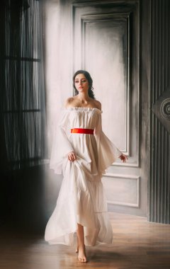 Sanat eseri, genç, güzel esmer. Koyu saçlı, çıplak omuzlu, beyaz, klasik, harika, ortaçağ lüks elbisesi. Arka plan gotik oda iç güneş ışığı. Fantezi üzgün gelin düğün rönesansı tarzı