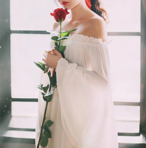 Titokzatos sziluett fiatal hercegnő. Fehér vintage ruha. Vörös rózsa a kezekben — Stock Fotó