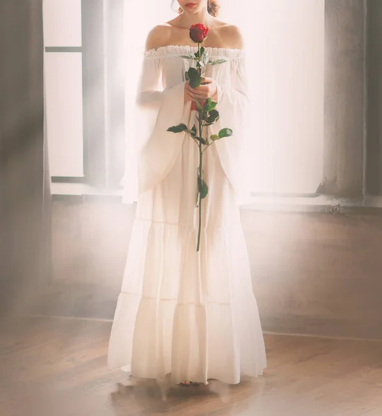 Vrouw blote schouders zonder gezicht in lange witte vintage sexy luxe jurk met rode roos — Stockfoto