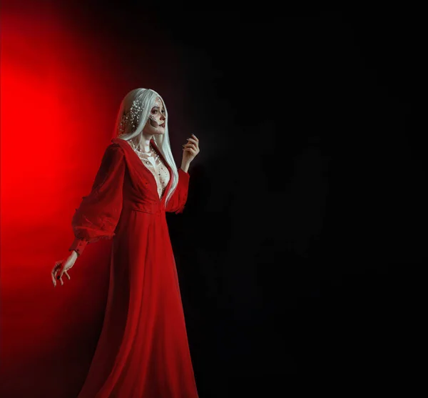 Young beautiful lady woman image goddess death. Blonde long hair. vintage dress. Backdrop red light black free space for text. Feast Day of Dead makeup paint face Sugar Skull. holiday event Halloween — Stock Photo, Image