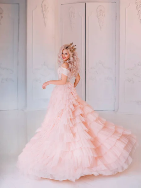 Cheerful beautiful princess girl blonde laugh smiling. Luxury ballroom evening elegant trendy tulle pink dress fluttering fly motion. Happy cute face Queen. woman enjoy holiday. Backdrop white room.