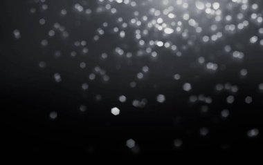 Soyut doku, siyah arka planda gümüş kıvılcımlar parlıyor. Lens sihirli beyaz gri kıvılcımlar saçar. Şenlikli Xmas duvar kağıdı. Sihirli parıltı parlıyor. Noel 'de Noel arkaplanı