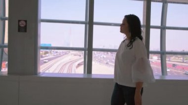 Yaya geçidinde yürüyen bir kadın turist. Yaya güvenliği. Beyaz bluz siyah çanta. Bayan Person metro istasyonundaki durağa gider. Modern şehir manzarası yolunda arabalı arka plan penceresi. Dubai BAE 4k 2020