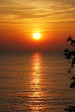 Akşamları denizin üzerinde büyük turuncu bir günbatımı. Akşamları denizin ortasında yatay dalgalar. Doğal arka plan kavramı. 