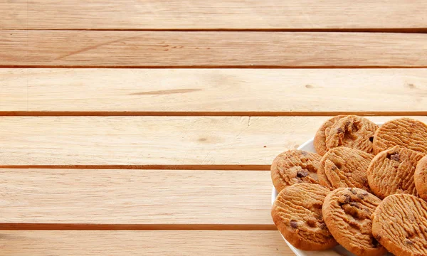 Biscuits au chocolat et thé mis sur bois — Photo