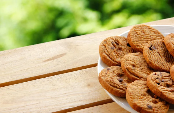 Biscuits au chocolat et thé mis sur bois — Photo