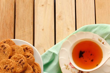 Çikolatalı kurabiye ve çay tahta üzerinde koymak