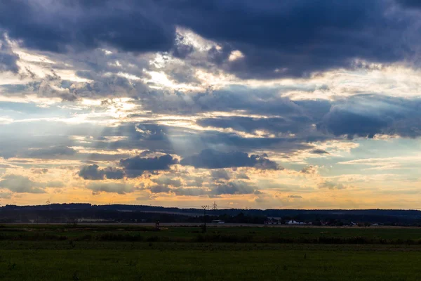 Weide en bewolkte hemel bij zonsondergang — Stockfoto