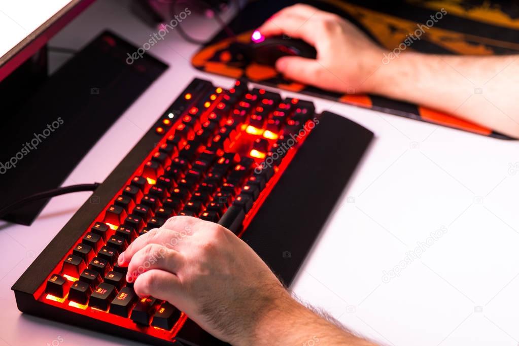 Man playing computer game on custom made desktop with joypad, ke