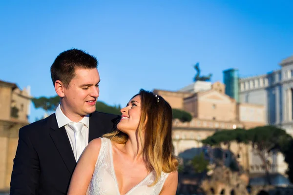 Novia y novio posan frente al Foro Romano, Roma, Ita — Foto de Stock