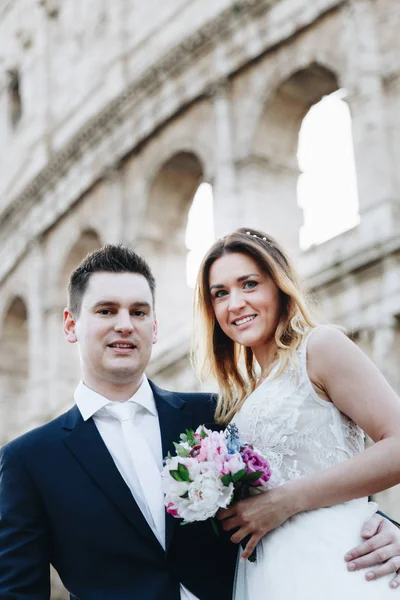 Novia y novio posan frente al Coliseo, Roma, Italia —  Fotos de Stock