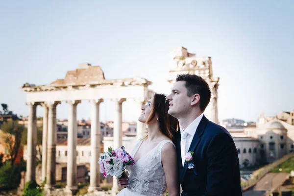 Novia y novio posan frente al Foro Romano, Roma, Ita — Foto de Stock