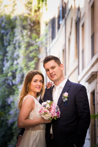 Bruden och brudgummen poserar på de gamla gatorna i Rom, Italien — Stockfoto