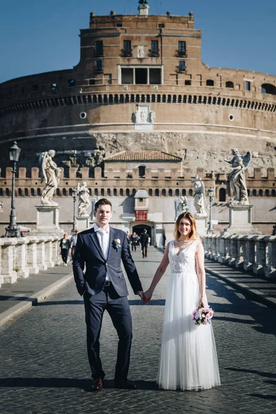 Novia y novio posan frente a Castel Sant 'Angelo, Ro —  Fotos de Stock