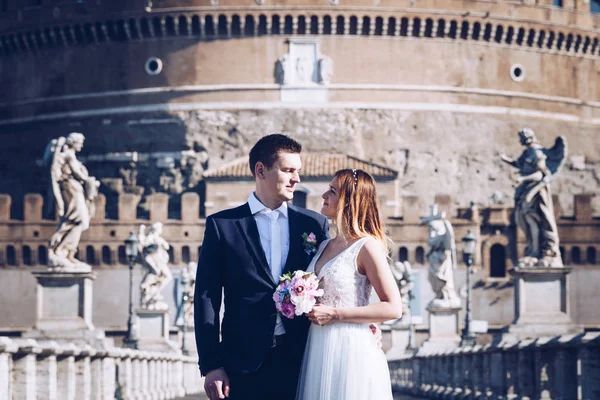 Novia y novio posan frente a Castel Sant 'Angelo, Ro —  Fotos de Stock