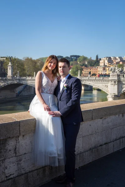Bruid en bruidegom bruiloft poses aan de oever van de rivier Tiber loo — Stockfoto