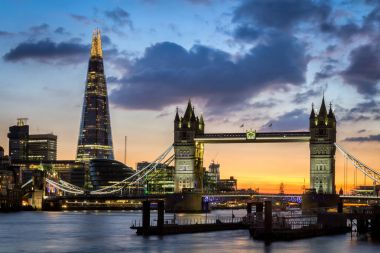 Tower Bridge Londra, İngiltere'de gün batımında yansımaları ile.