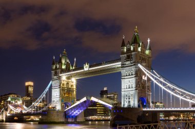 Tower Bridge Londra, İngiltere'de gün batımında yansımaları ile.