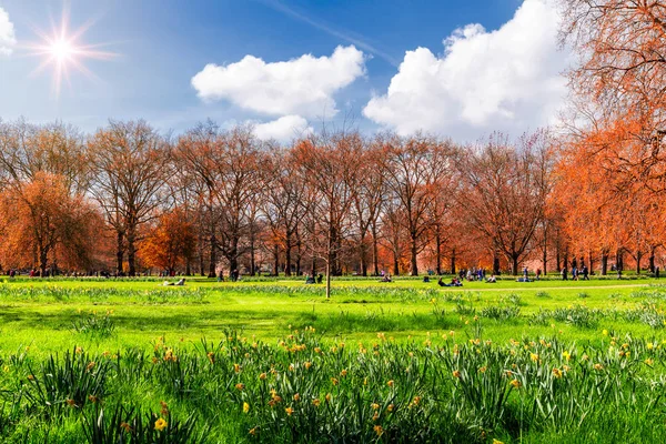 Parque verde en Londres durante el cálido día de primavera. Personas sentadas en t —  Fotos de Stock