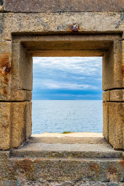 Ocean viewed through window of stone wall — Stock Photo, Image