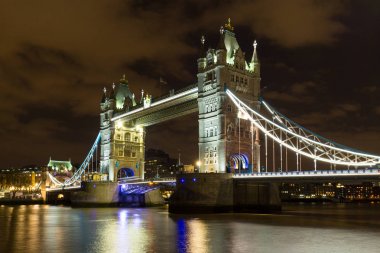 Tower Bridge Londra, İngiltere'de gün batımında yansımaları ile.