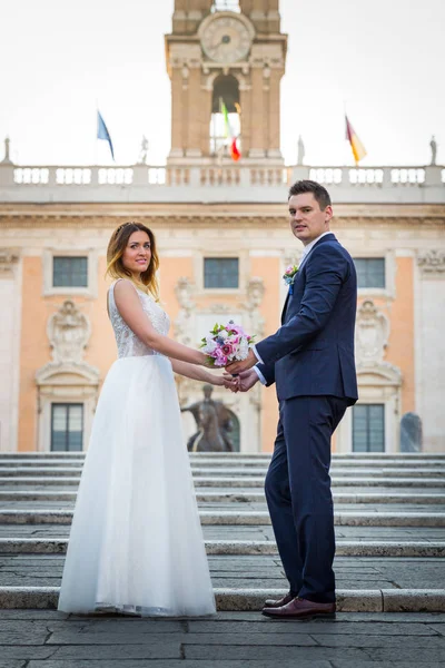 Novia y novio posan frente al Capitolio (Campidog — Foto de Stock