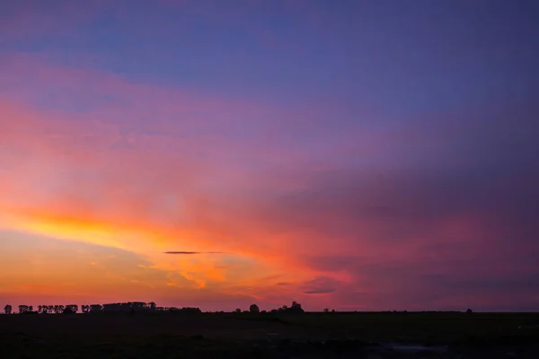 Natuurlijke zonsondergang zonsopgang boven veld of weide. Heldere dramatische hemel — Stockfoto