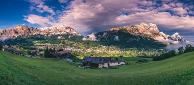 Cortina d'Ampezzo town panoramic view with alpine green landscape and massive Dolomites Alps in the background. Province of Belluno, South Tyrol, Italy. clipart