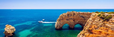Marinha plajında doğal mağaralar, Algarve Portekiz. Kayalık yay