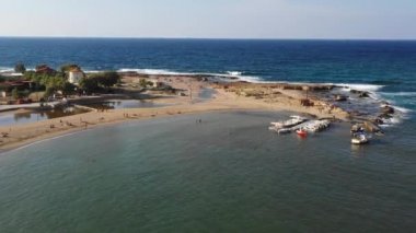 Stavros, Hanya, Girit adası, Yunanistan küçük bir kalp şeklinde lagün ve dağlık deniz manzarası oluşturan turkuaz organize plaj havadan drone üst görüntüleme video. Stavros Plajı; Stavros, Girit, Yunanistan.