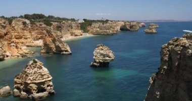 Marinha sahilindeki doğal mağaralar, Algarve Portekiz. Marinha sahilindeki kayalık kemerleri ve Algarve bölgesindeki Portekiz kıyılarındaki turkuaz deniz suyu..