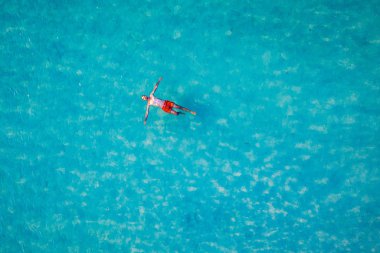 Drone view of a man floating in tropical sea water. Aerial view 
