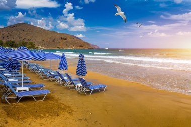 Yunanistan 'ın ada beldesinde turistleri bekleyen güneşli yatakların manzarası 