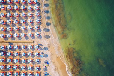 Aerial drone top view of turquoise organised beach forming a sma