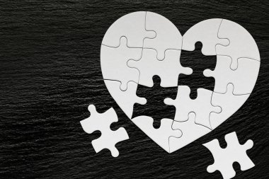 Renk arka planda kalp şeklinde yapboz. Puzzle kalp üzerinde 
