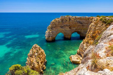 Marinha plajında doğal mağaralar, Algarve Portekiz. Kayalık yay