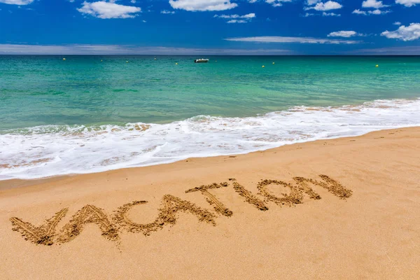 Vacation text on a beach. Vacation written in a sandy tropical b — Stock Photo, Image