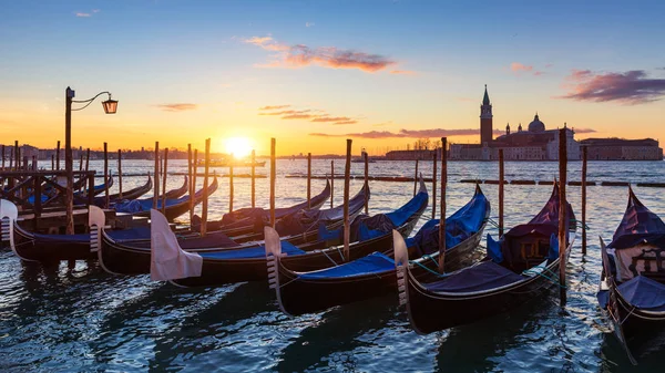 Venice with famous gondolas at sunrise, Italy. Gondolas in lagoo — Stok fotoğraf