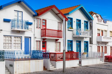 Kosta Nova, Aveiro, Portekiz 'de renkli evleri olan bir cadde. Çizgili evleri olan cadde, Costa Nova, Aveiro, Portekiz. Kosta Nova, Aveiro, Portekiz 'deki renkli evlerin cepheleri.
