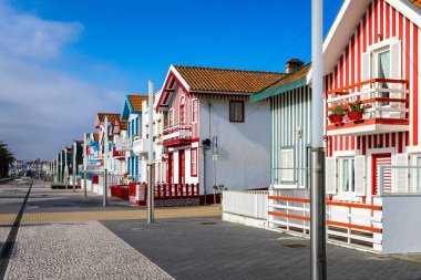 Kosta Nova, Aveiro, Portekiz 'de renkli evleri olan bir cadde. Çizgili evleri olan cadde, Costa Nova, Aveiro, Portekiz. Kosta Nova, Aveiro, Portekiz 'deki renkli evlerin cepheleri.
