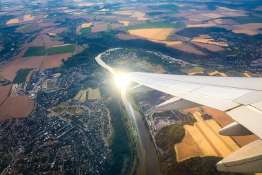 Uçak pencereleri yerin üzerinde, simgesel yapının üzerinde bir görünüme sahiptir. Bir uçak penceresinden, tarım arazileri ve tarlaların üzerinde uçan bir kanadın üzerinden bakın. Uçan uçak penceresinden görünüm.