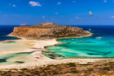 Yunanistan 'da Girit' teki Balos Lagoon ve Gramvousa adaları üzerinde martılar uçuşuyor. Kaptan Tigani ortada. Yunanistan 'ın Girit adasındaki Balos plajı. Balos sahilinin berrak suyu.