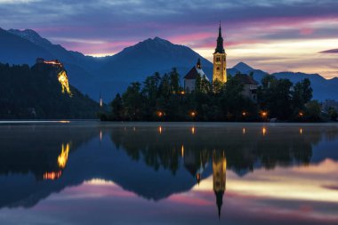 Dramatic sunrise on lake Bled, sunrise view on Bled lake, island, Pilgrimage Church of the Assumption of Maria and Castle with mountain range (Stol, Vrtaca, Begunjscica). Bled, Slovenia, clipart