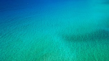 Deniz yüzeyi havadan görünüyor. Turkuaz denizin arkaplan görüntüsü. Derin deniz ve mercanlar. Turkuaz suyun havadan drone görüntüsü, metin için boşluk. Aquamarine geçmişi. Deniz Havası Görünümü.