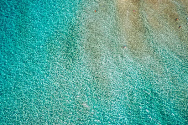 People swimming in the sea. Aerial view, Top view. The color of the water and beautifully bright. Swimming and relaxing in the sea blue lagoon aerial top view. Top view from flying drone.