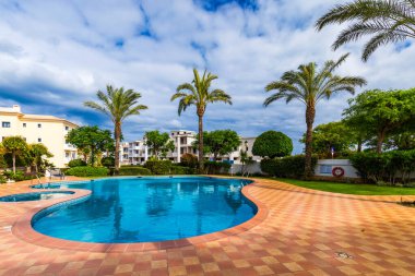 Yüzme havuzu, jakuzi ve şezlonglar ile büyük arka bahçesinde. Arka bahçede yüzme havuzu. Güneşli bir günde palmiye ağaçları ve çiçeklerile inanılmaz yüzme havuzu ve bahçe.