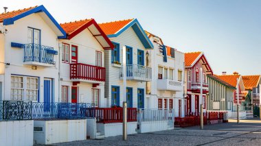 Kosta Nova, Aveiro, Portekiz 'de renkli evleri olan bir cadde. Çizgili evleri olan cadde, Costa Nova, Aveiro, Portekiz. Kosta Nova, Aveiro, Portekiz 'deki renkli evlerin cepheleri.