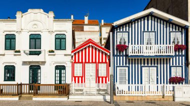 Kosta Nova, Aveiro, Portekiz 'de renkli evleri olan bir cadde. Çizgili evleri olan cadde, Costa Nova, Aveiro, Portekiz. Kosta Nova, Aveiro, Portekiz 'deki renkli evlerin cepheleri.