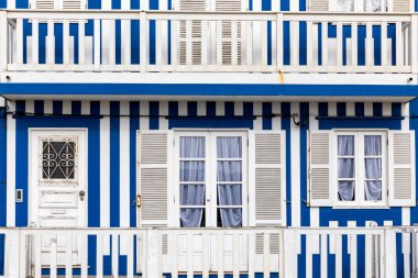 Kosta Nova, Aveiro, Portekiz 'de renkli evleri olan bir cadde. Çizgili evleri olan cadde, Costa Nova, Aveiro, Portekiz. Kosta Nova, Aveiro, Portekiz 'deki renkli evlerin cepheleri.
