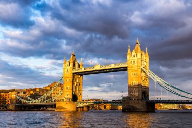 Tower Bridge Londra, İngiltere'de gün batımında yansımaları ile.
